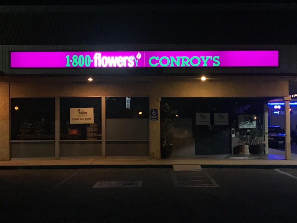 1-800-Flowers storefront lighted box sign at night