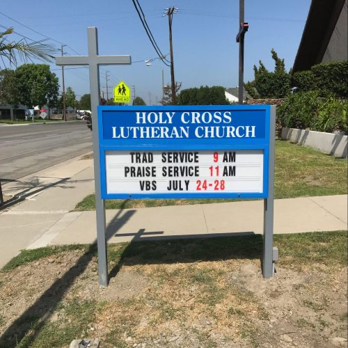 a blue Holy Cross Lutheran Church monument sign.